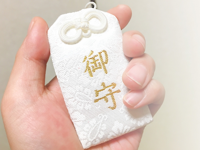 手のひらにのせた白いお守り